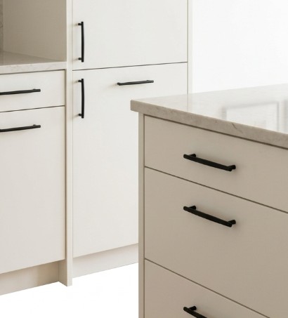 Matte black bar handles on cream and taupe kitchen cabinets